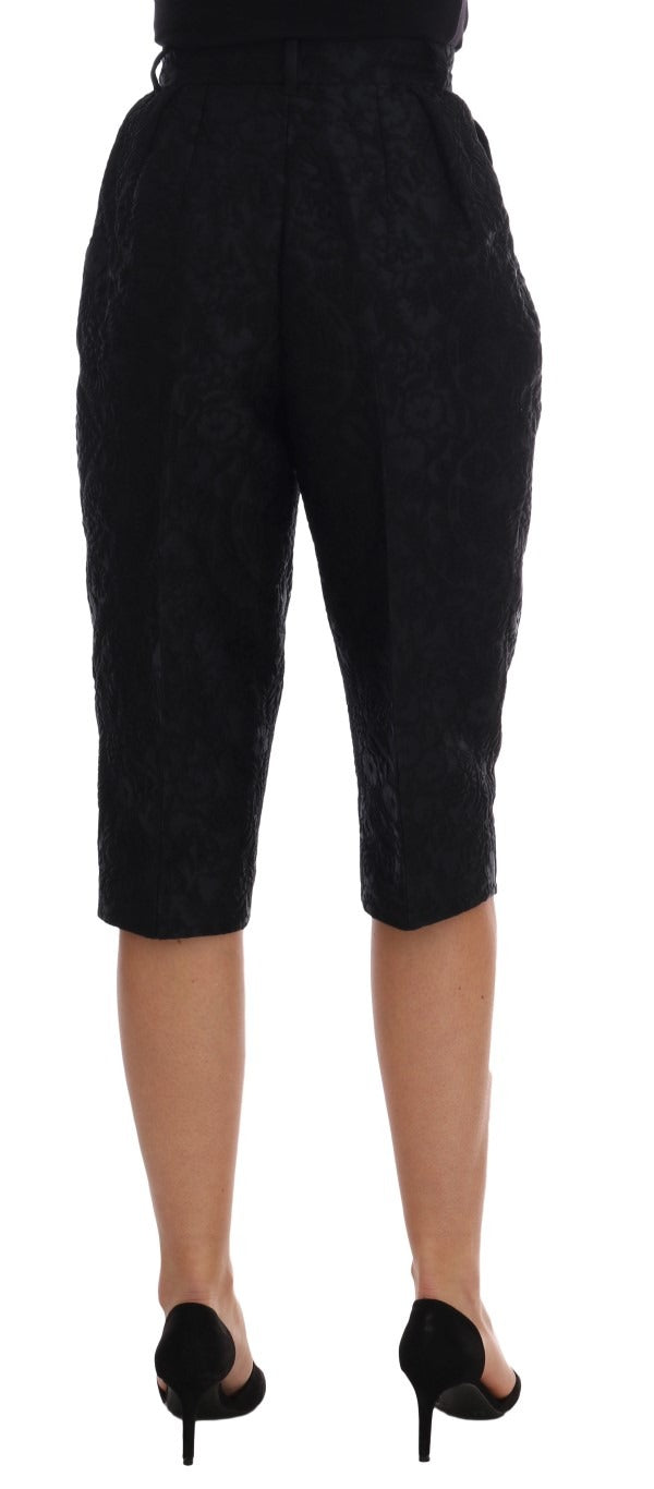 Black brocade high waist Capri shorts by Dolce & Gabbana with intricate floral pattern and tailored fit.