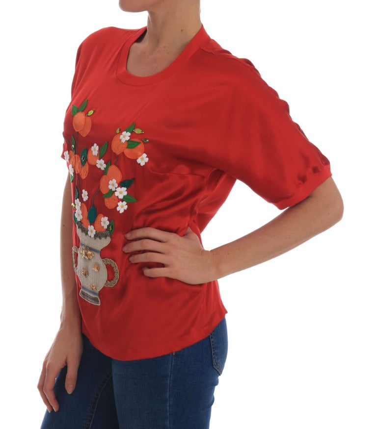 Red silk floral blouse with orange and crystal embellishments by Dolce & Gabbana, shown on a model.