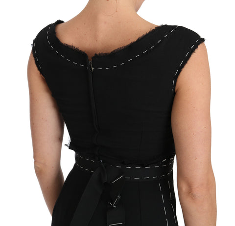 Black wool stretch A-line sheath dress by Dolce & Gabbana hanging on a wooden hanger.