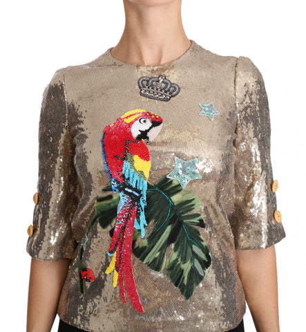 Gold sequined Dolce & Gabbana parrot crystal blouse with intricate embroidery and vibrant feather details.