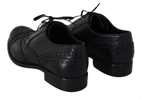 Dark blue leather wingtip Oxford dress shoes by Dolce & Gabbana with detailed brogue accents and sleek polished finish.