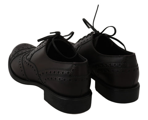 Black leather wingtip oxford dress shoes by Dolce & Gabbana, featuring classic brogue detailing and sleek lace-up design.