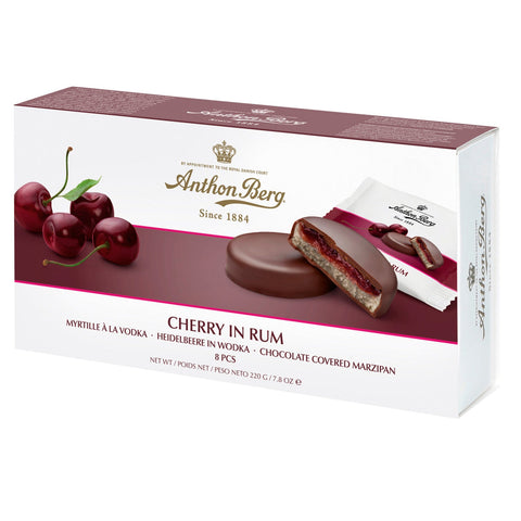 Anthon Berg cherry in rum marzipan wrapped in dark chocolate, displayed on a white plate with a dark background.