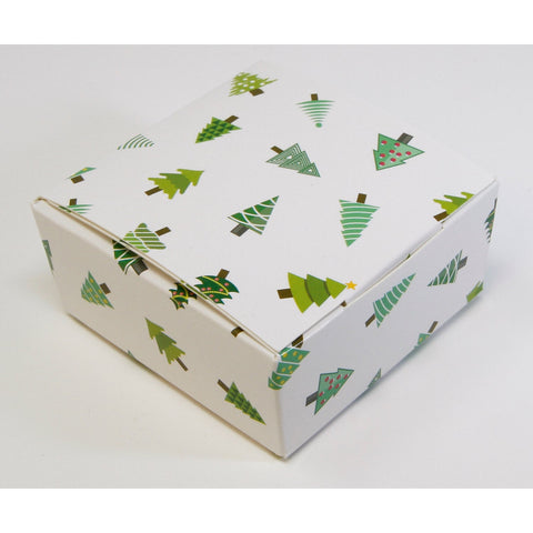 White chocolate box with Christmas tree design from Jag Couture London - New York, featuring four assorted chocolates in festive packaging.