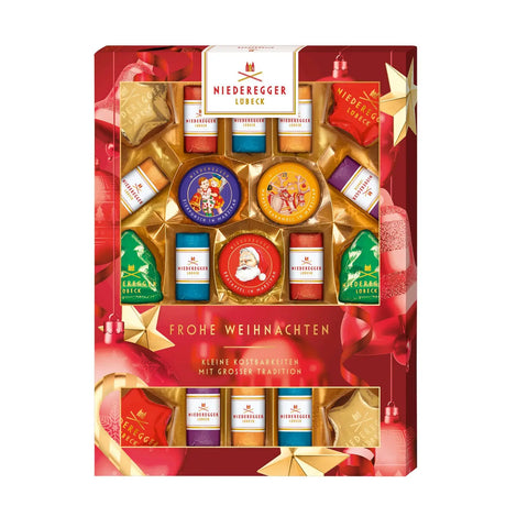 Assorted marzipan treats from Christmas Marzipanerie by Jag Couture London New York, arranged in festive holiday packaging.