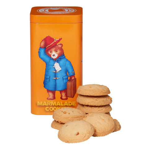 Paddington Bear keepsake gift tin containing orange marmalade cookies by Jag Couture London New York, with colorful bear illustration.