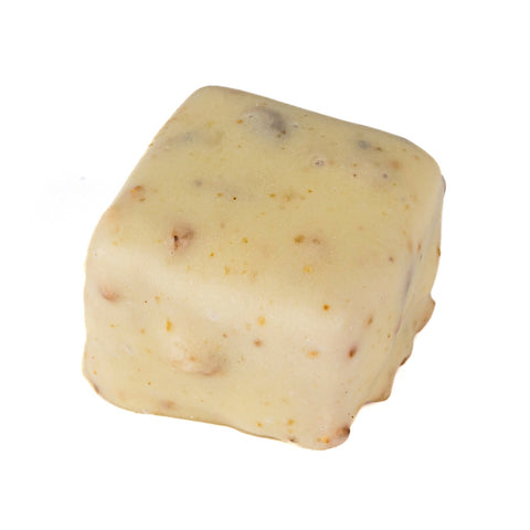 White chocolate nougatine square with hazelnut praline by Jag Couture London, shown in close-up with a smooth, glossy surface.