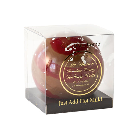 Single milk chocolate bomb by Jag Couture London in acetate gift box, showcasing a smooth, creamy chocolate sphere.