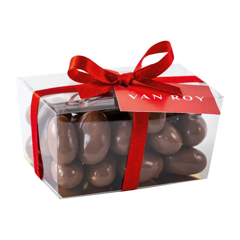 Milk chocolate Brazil nuts in a cello ballotin with ribbon, by Jag Couture London & New York, displayed in an elegant presentation.