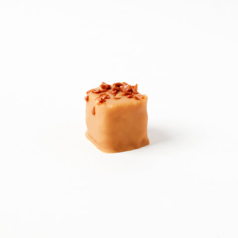Jag Couture London New York Double Caramel salted butter caramel chocolate coconut praline 15g, close-up of the flavored chocolate treat