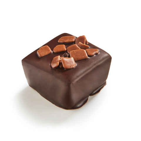 Piece of Piro bitter ganache in 72% dark chocolate by Jag Couture London-New York, showing smooth, glossy dark chocolate texture.