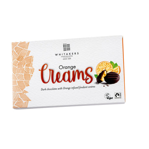 Dark chocolate covered orange fondant creams by Jag Couture London in a carton, showcasing glossy chocolate coating and vibrant orange filling.