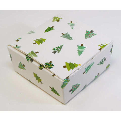 White chocolate gift box with Christmas tree design by Jag Couture London New York, featuring four assorted chocolates.