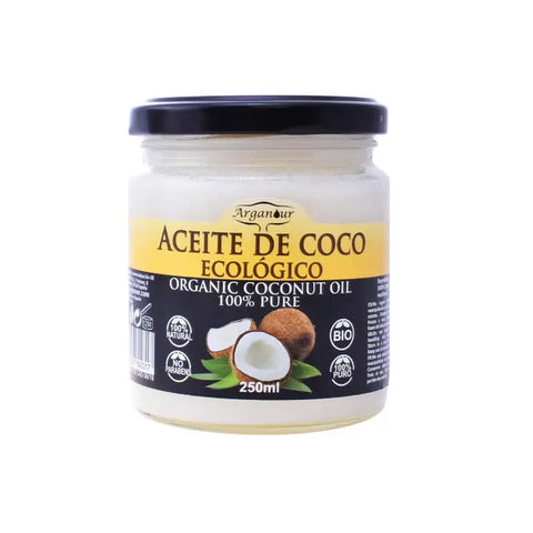 Organic coconut oil in a 250ml jar from Arganour, displayed with a natural coconut and lush green leaves.