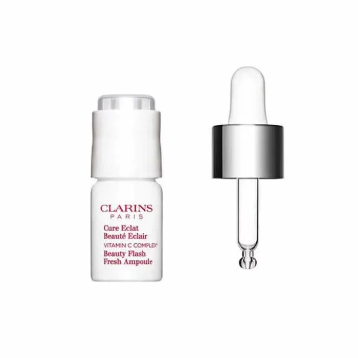 Clarins Beauty Flash Fresh Ampoule 8ml, clear glass vial with golden cap, showcasing a skincare ampoule from Jag Couture London New York.
