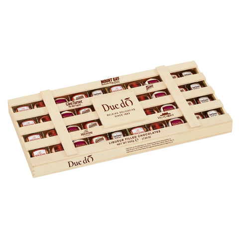 Duc d'O wooden crate of assorted liqueur-filled chocolates with sugar crust by Jag Couture London - New York, displayed in a rustic wooden box.