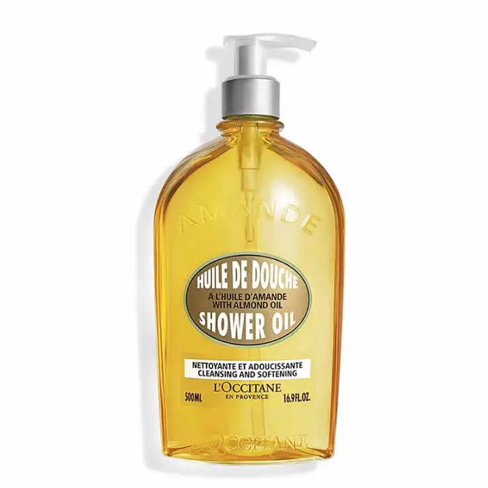 L'Occitane Amande Shower Oil 500ml in a clear bottle with a pump dispenser, featuring almond illustrations and a gold cap.