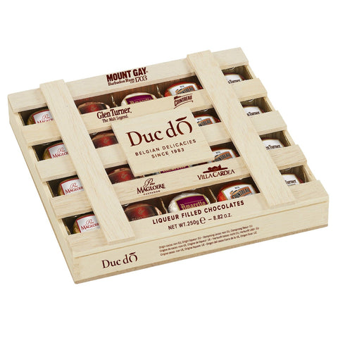 Duc d'O wooden crate of assorted liqueur-filled chocolates with sugar crust by Jag Couture London - New York, displayed in the image.
