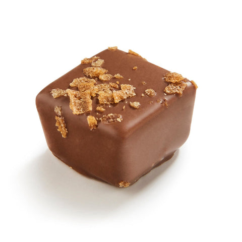 Halliday Milk praline with feuilletine in milk chocolate from Jag Couture London, showing the chocolate-coated treat with textured filling