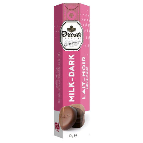 Milk and dark chocolate pastilles in a tube by Jag Couture London New York, showcasing shiny chocolate candies inside a sleek container.
