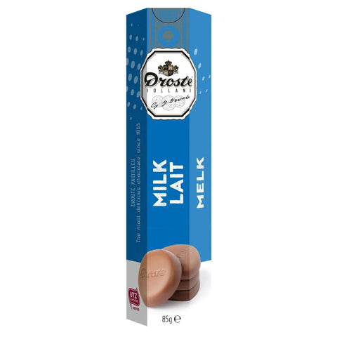 Milk chocolate pastilles in a tube by Jag Couture London New York, showcasing shiny, smooth chocolate pieces inside a sleek container.