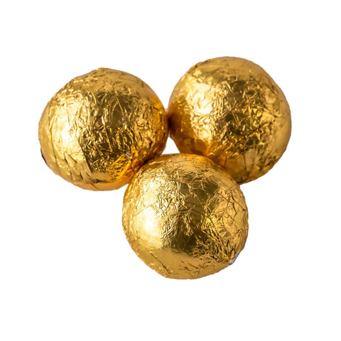 Solid milk chocolate balls wrapped in shiny gold foil by Jag Couture London - New York, displayed in a close-up image.